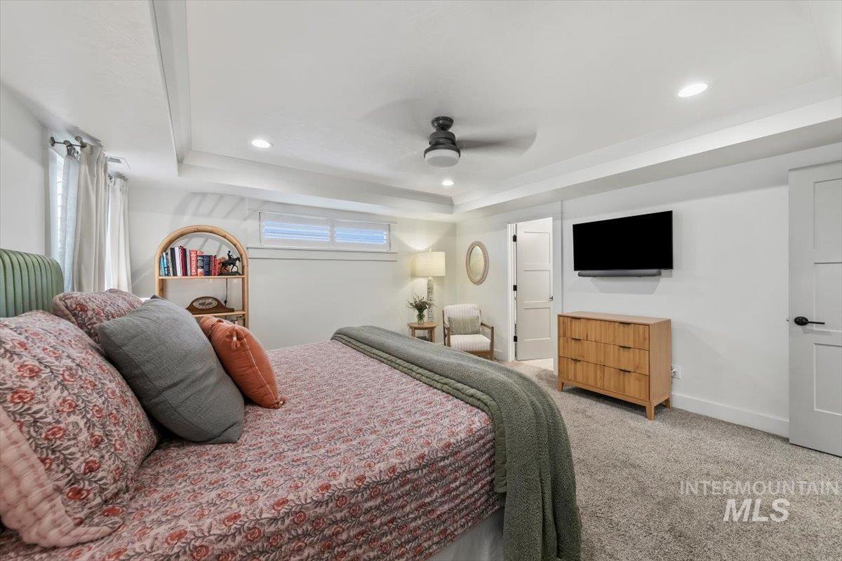 Bedroom featuring a raised ceiling, carpet floors, ceiling fan, and recessed lighting