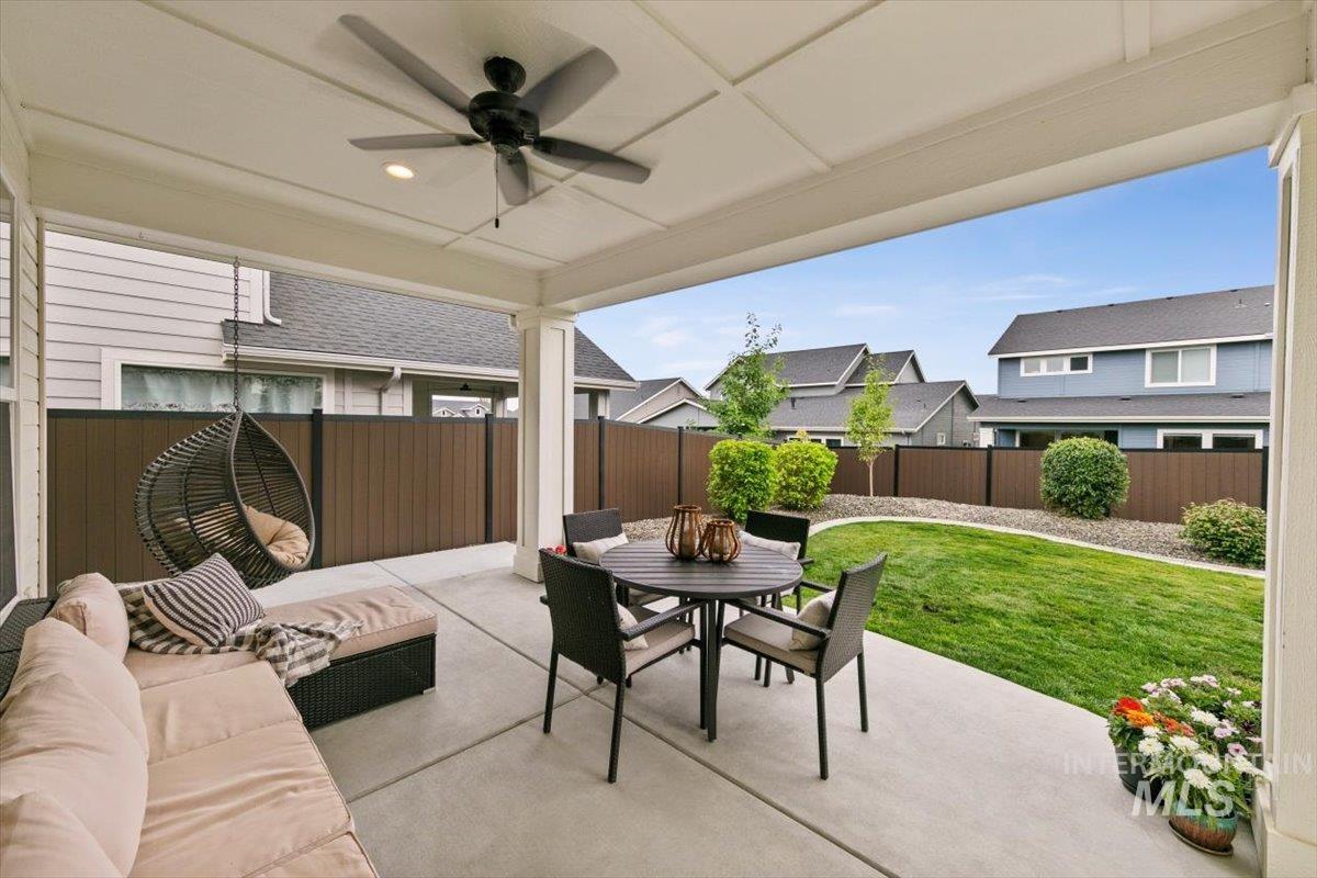 Fenced backyard featuring a patio area, outdoor dining space, and a ceiling fan