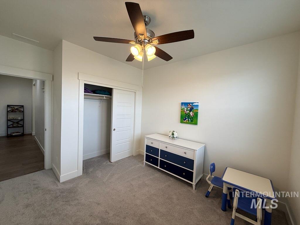 Carpeted bedroom with a closet and ceiling fan