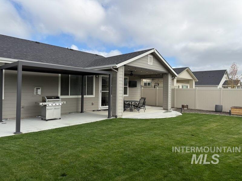 Back of house featuring a patio area and a shingled roof