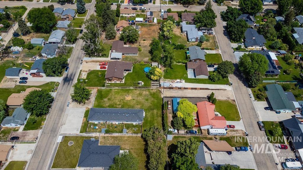 Aerial view of property and surrounding area featuring nearby suburban area