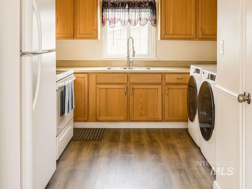 Washroom featuring washing machine and dryer and dark wood-style flooring