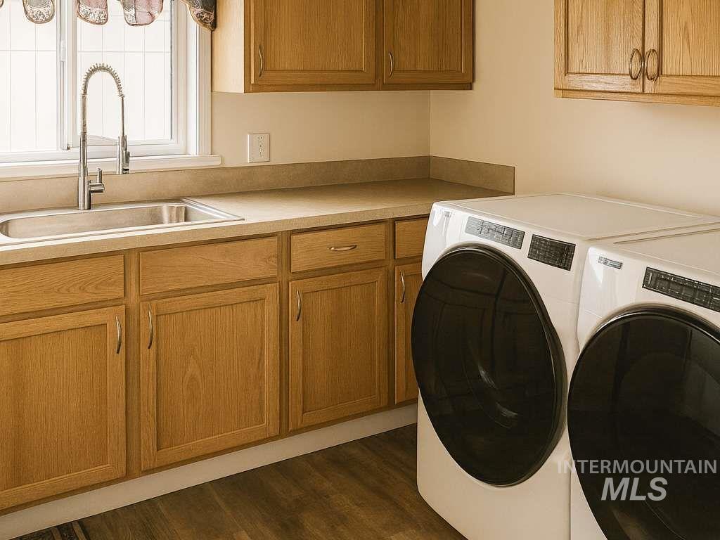 Washroom featuring cabinet space, separate washer and dryer, and dark wood-style floors