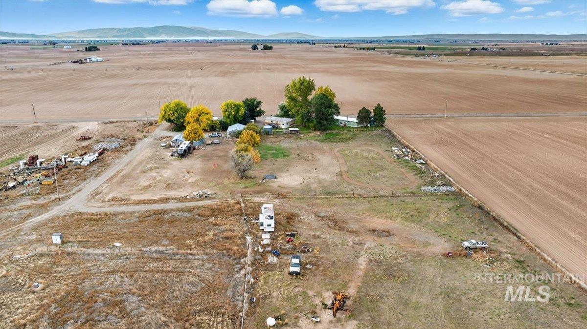 Aerial view of property and surrounding area featuring rural landscape and mountains