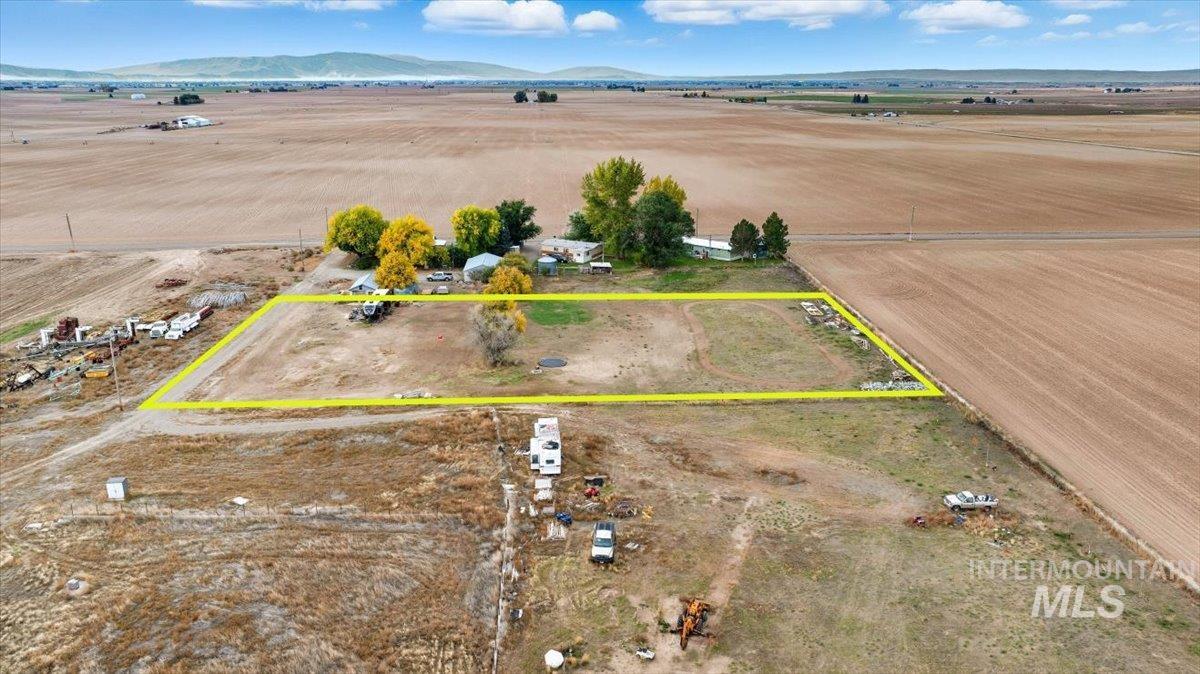View of rural area featuring a mountainous background and property parcel outlined