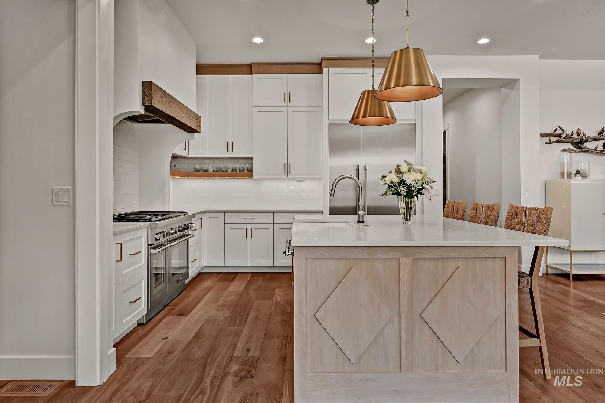 Kitchen with white cabinetry, tasteful backsplash, open shelves, light wood-style flooring, and high end appliances