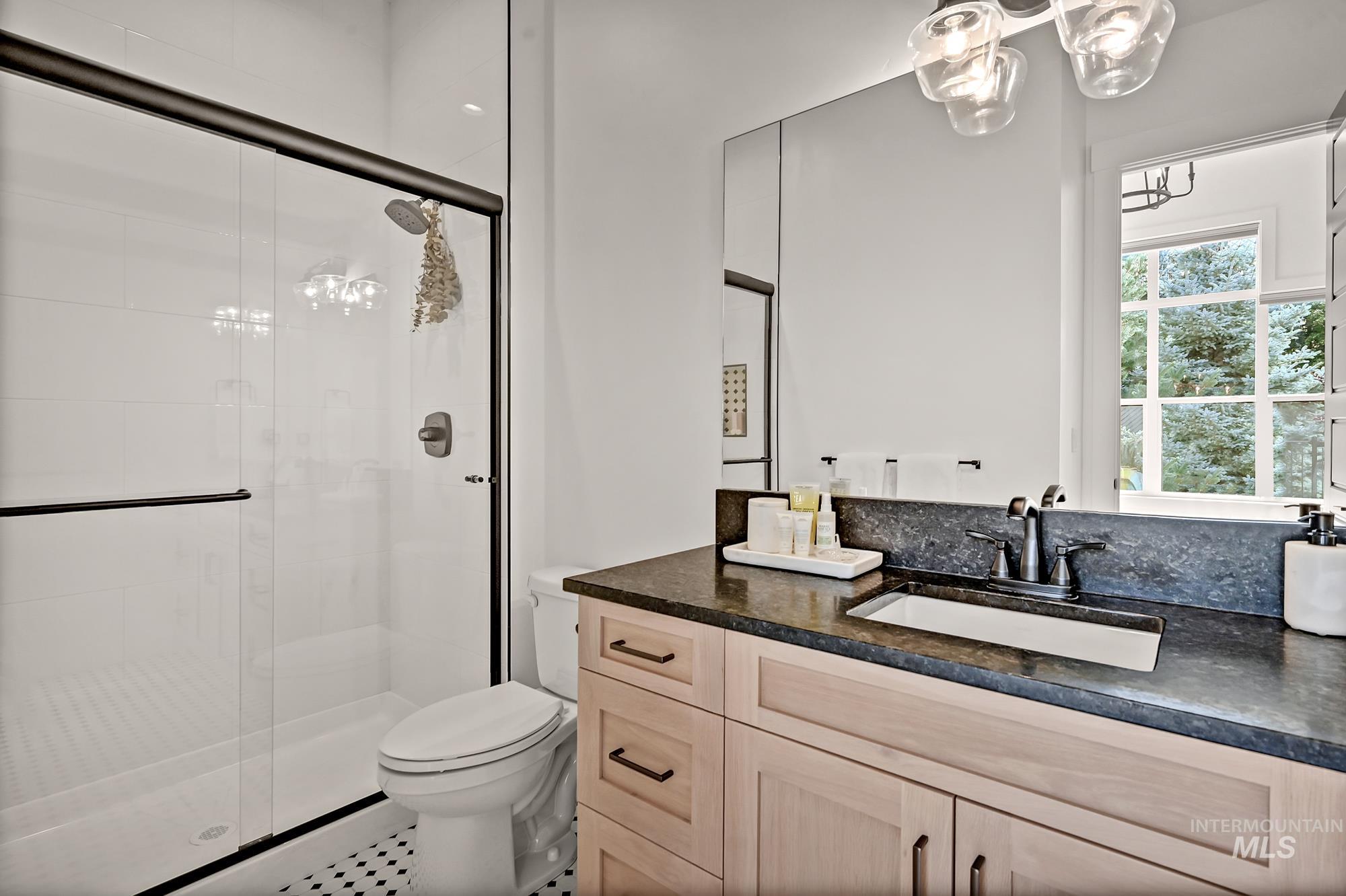 Full bathroom with a shower stall, vanity, and tile patterned flooring