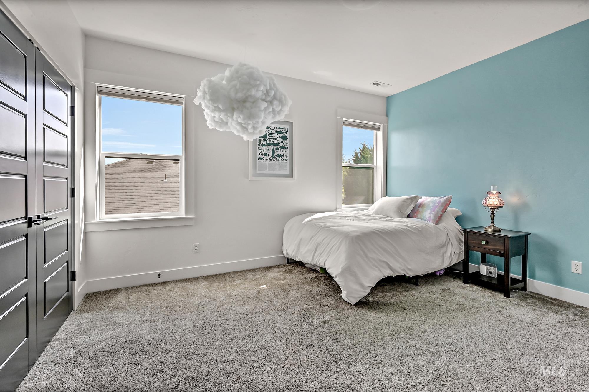 Bedroom with light colored carpet and baseboards