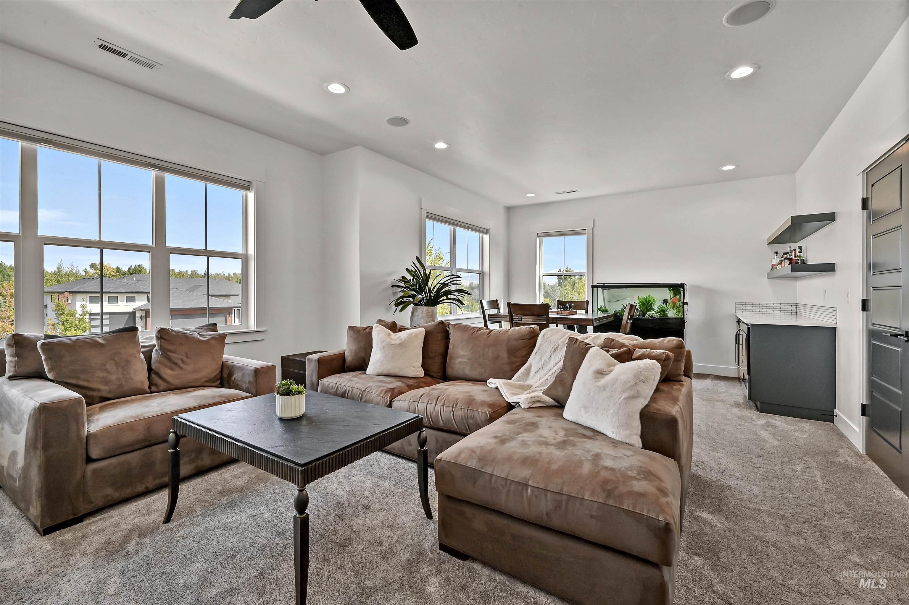 Living area with light colored carpet and recessed lighting