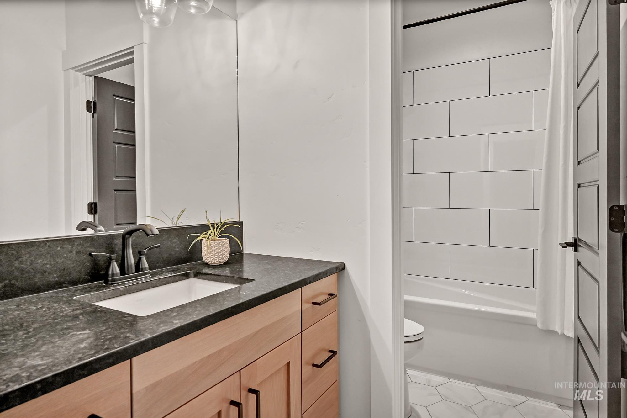 Full bathroom with vanity, light tile patterned floors, and  shower combination