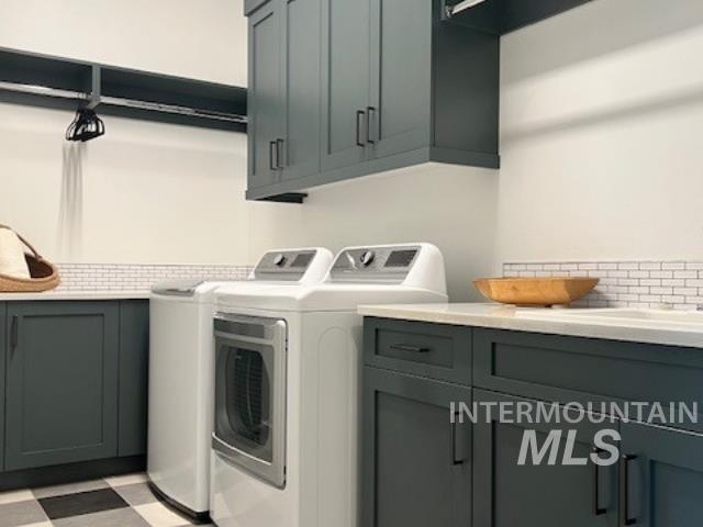 Laundry area with light flooring, independent washer and dryer, and cabinet space