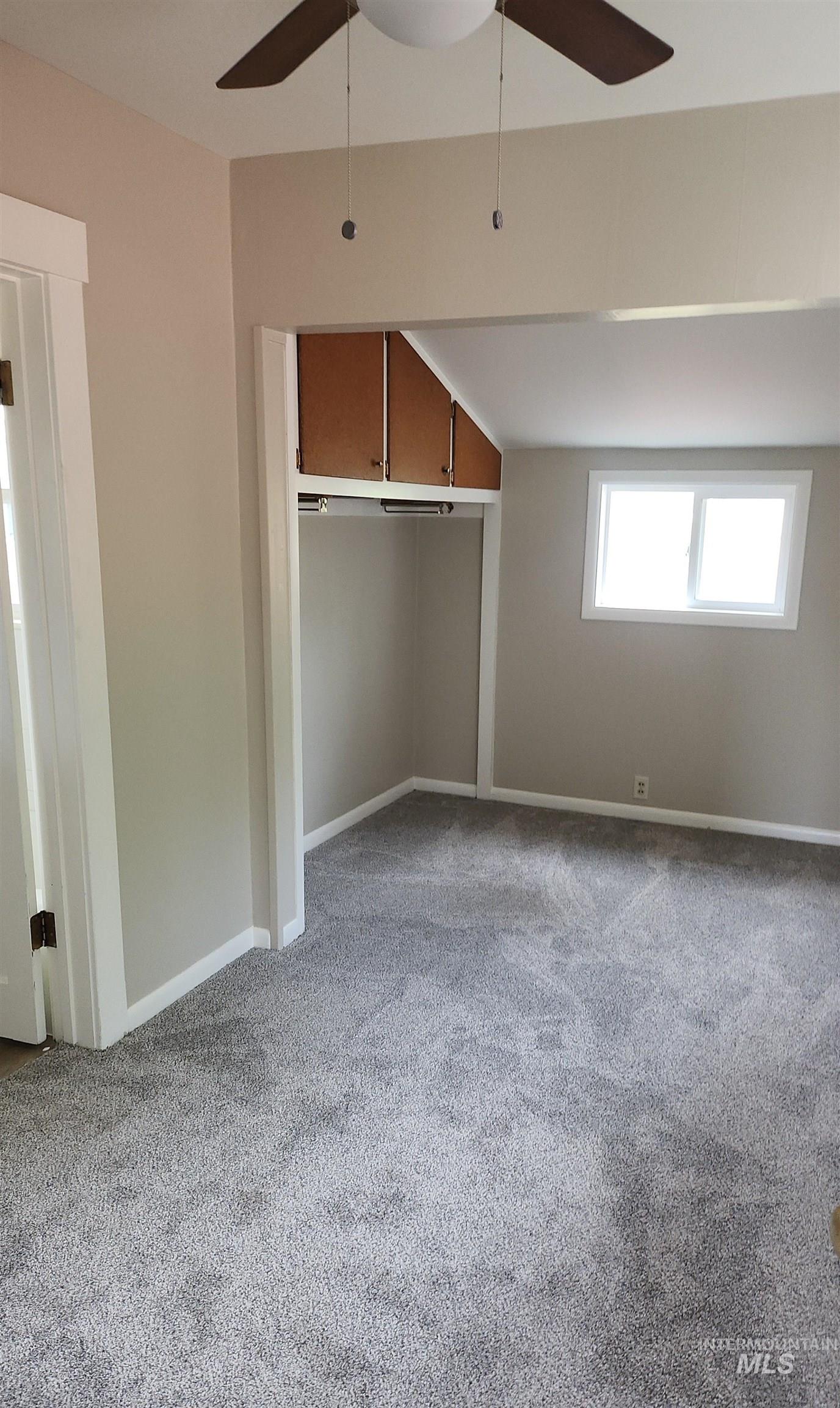 Unfurnished bedroom featuring light carpet, ceiling fan, and a closet