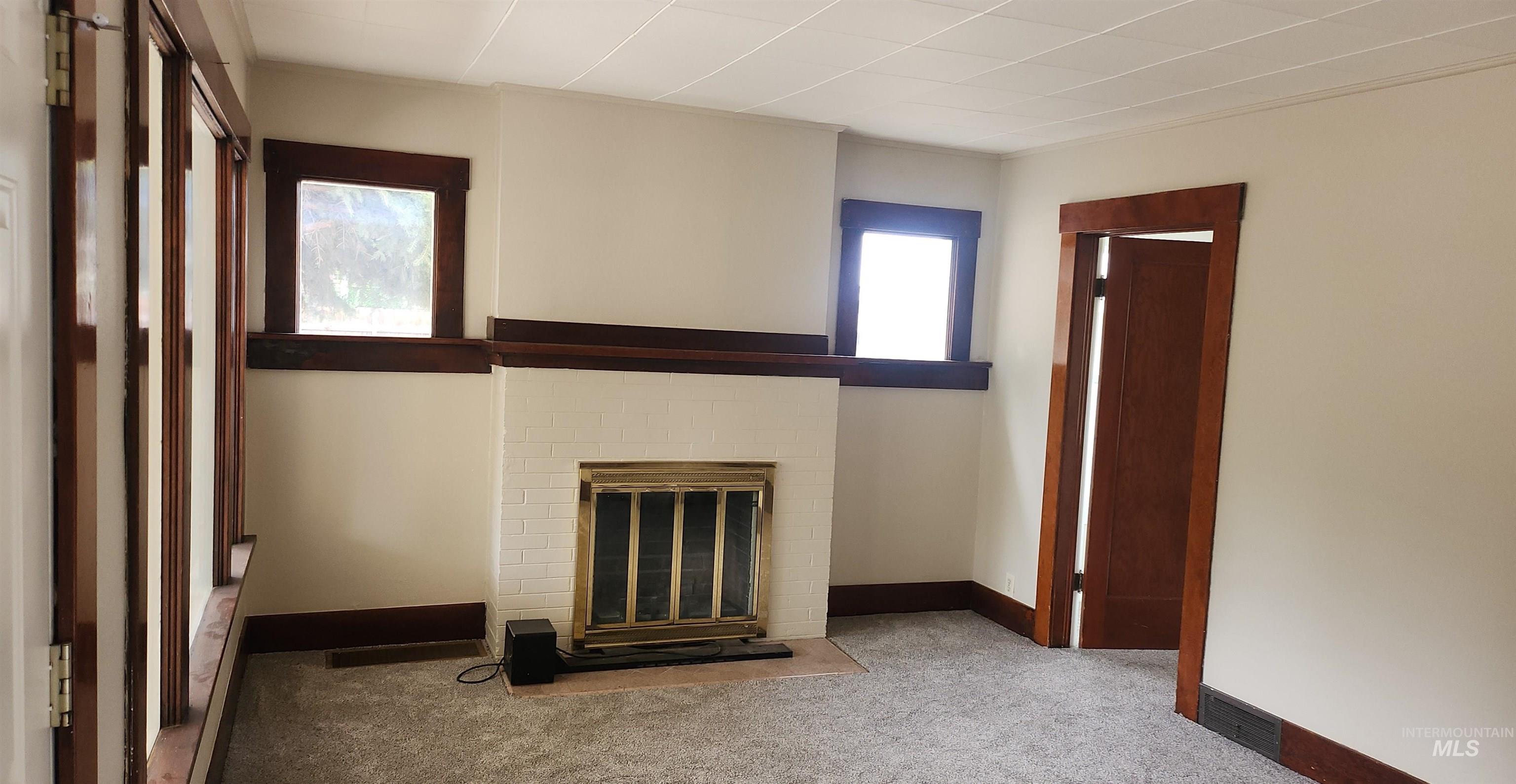 Unfurnished living room with carpet floors and a fireplace
