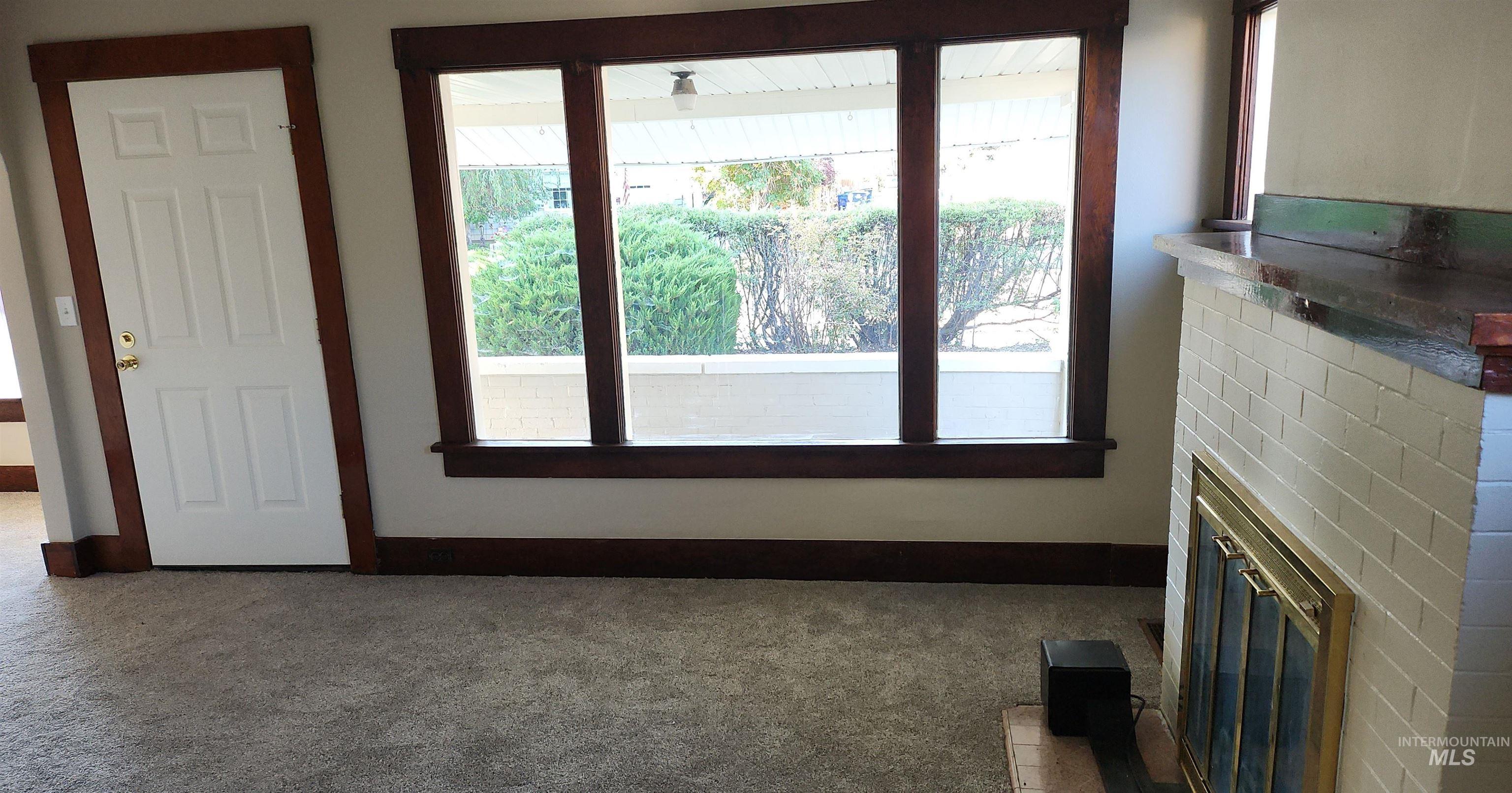 Unfurnished living room featuring carpet and a fireplace