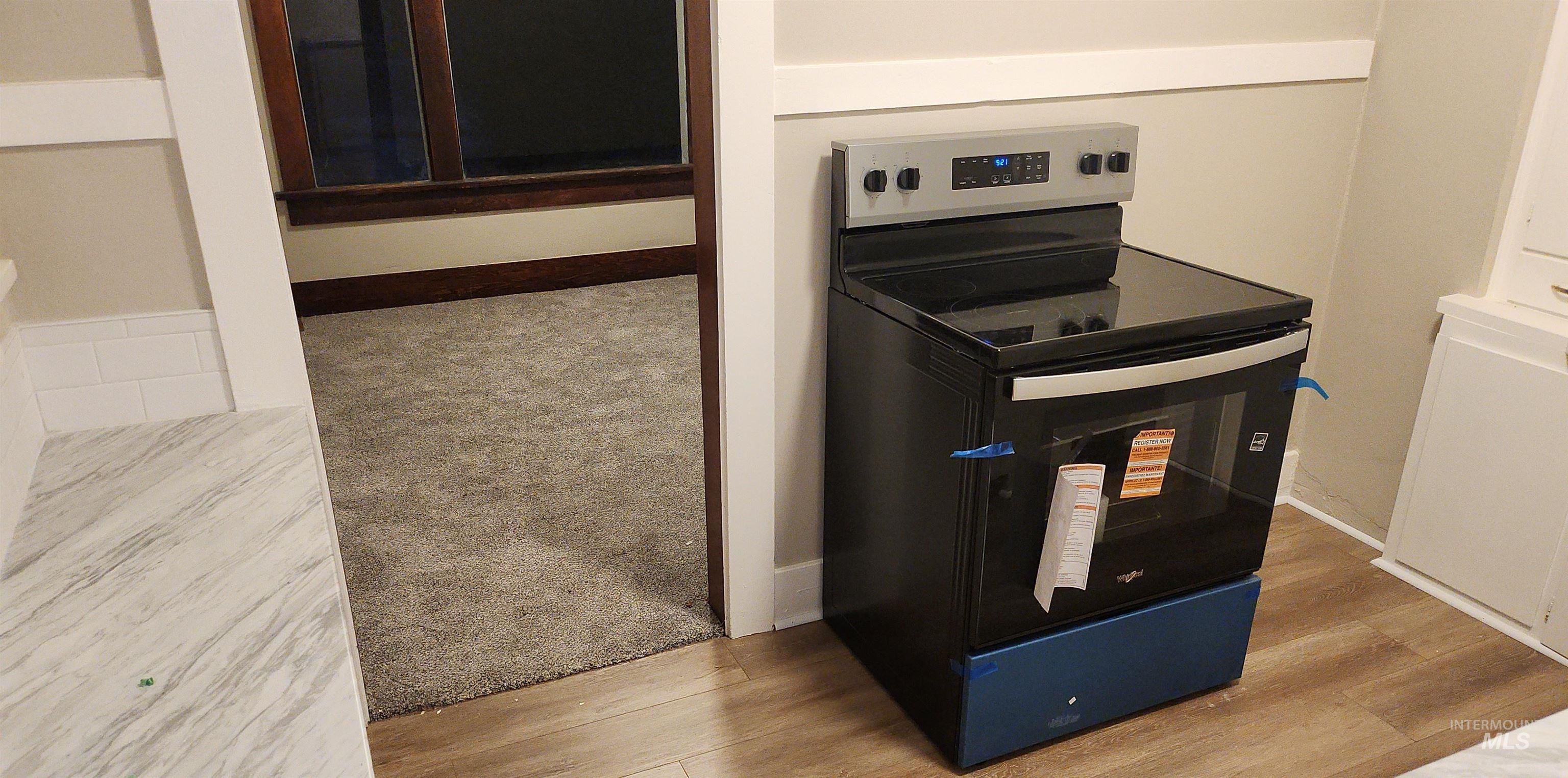 Detailed view of stainless steel electric range oven and light wood-style floors