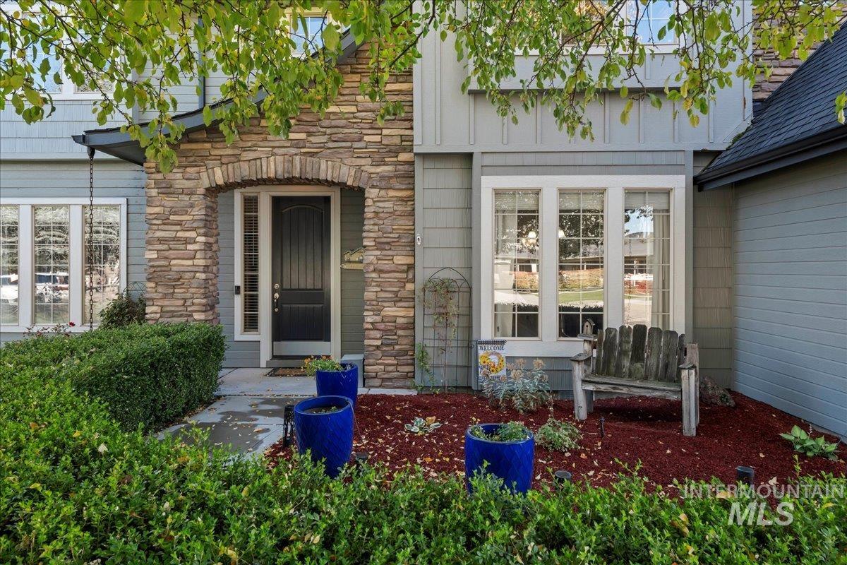 View of exterior entry with stone siding and board and batten siding