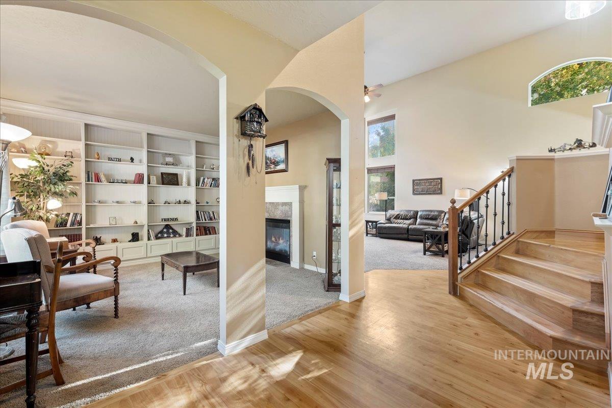 Interior space with plenty of natural light, stairs, light wood-type flooring, and a glass covered fireplace