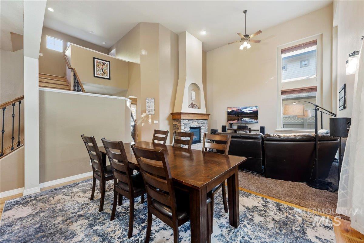 Dining room with a fireplace, plenty of natural light, ceiling fan, light wood finished floors, and recessed lighting
