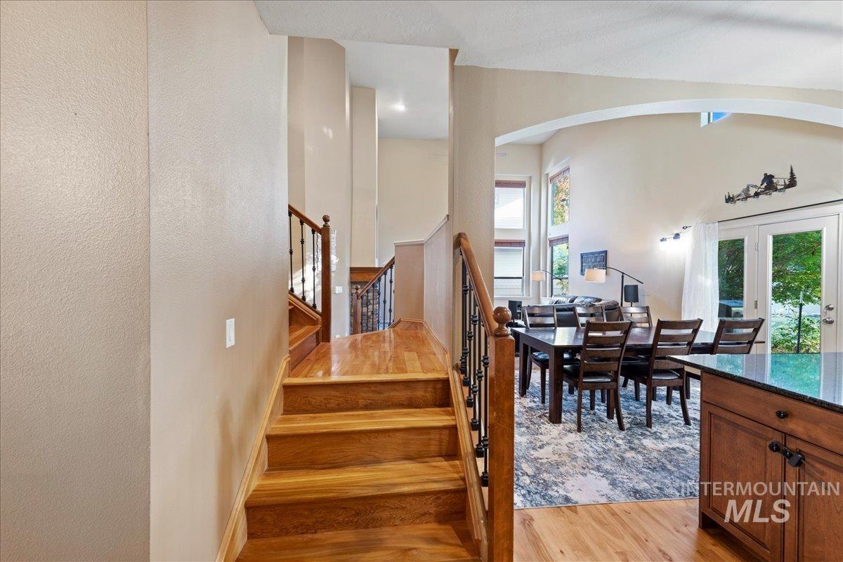 Stairway featuring wood finished floors, french doors, and arched walkways