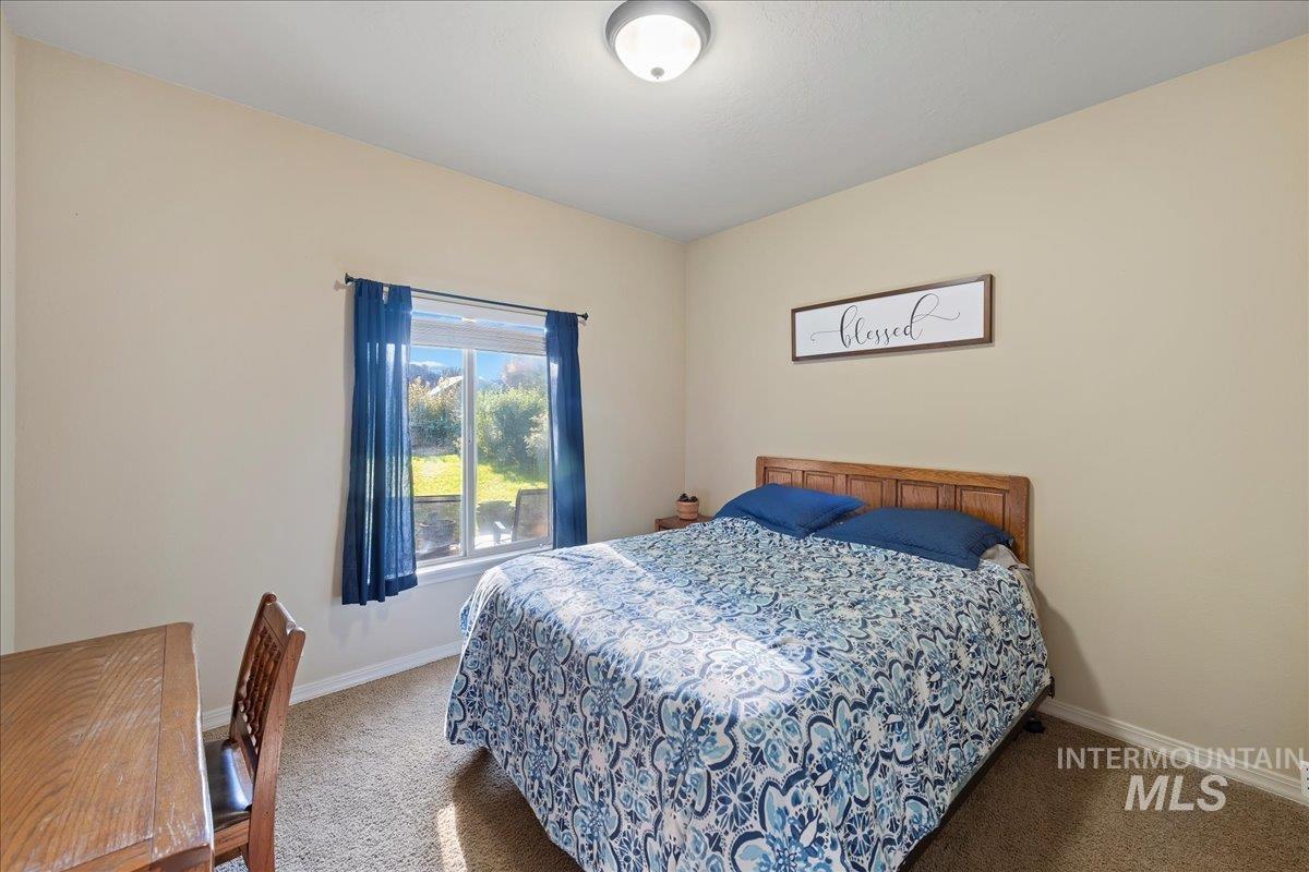Bedroom featuring carpet flooring and baseboards