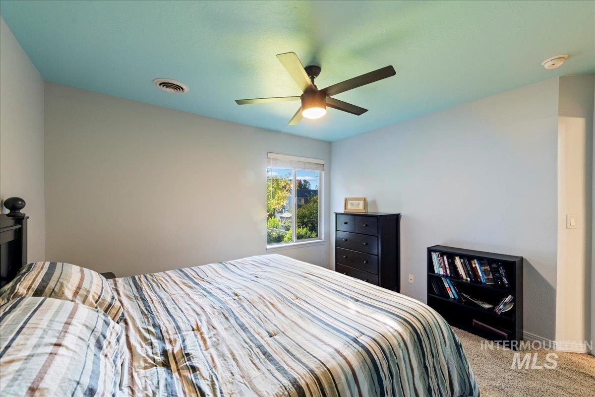 Carpeted bedroom with a ceiling fan