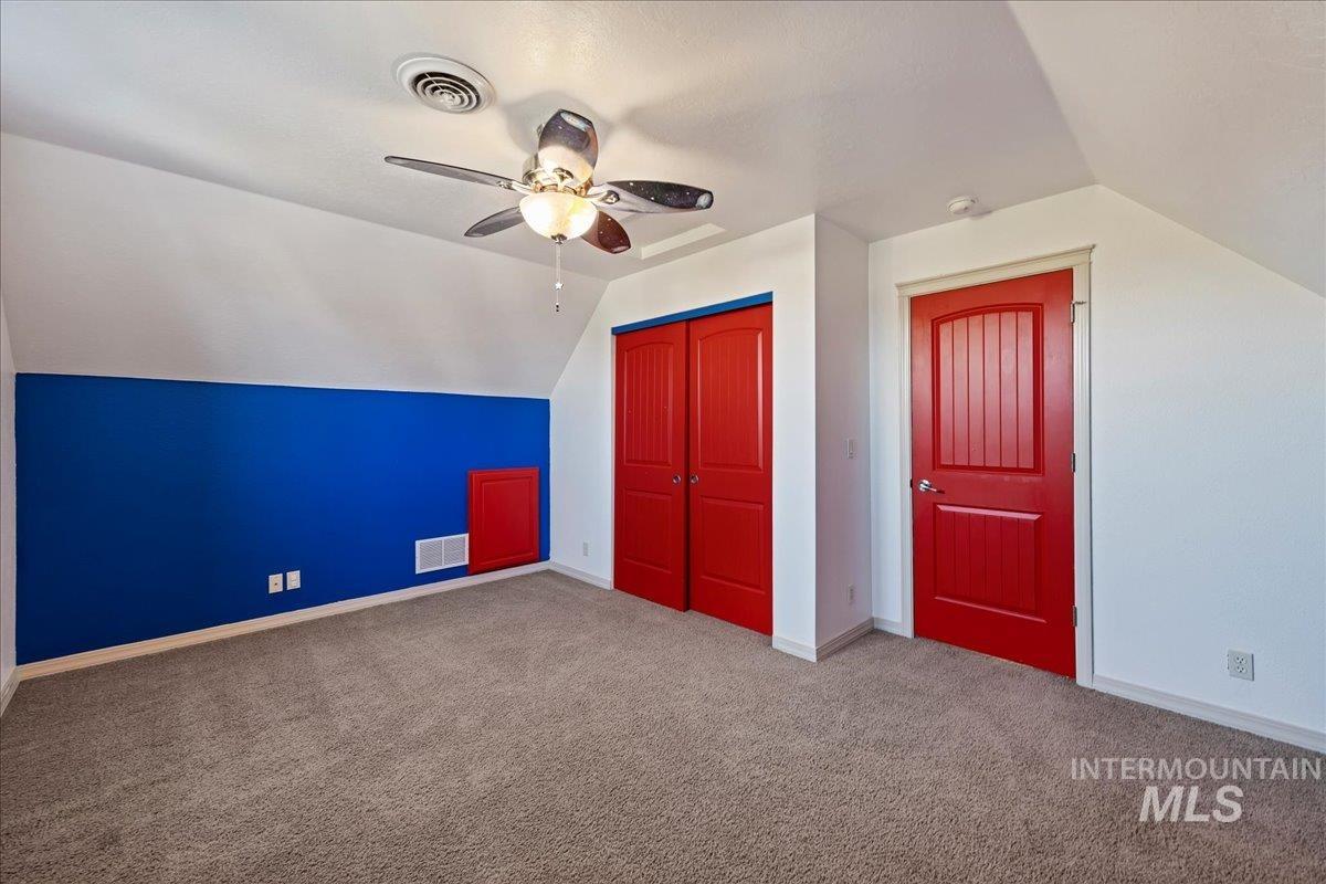 Additional living space with lofted ceiling, carpet floors, and ceiling fan