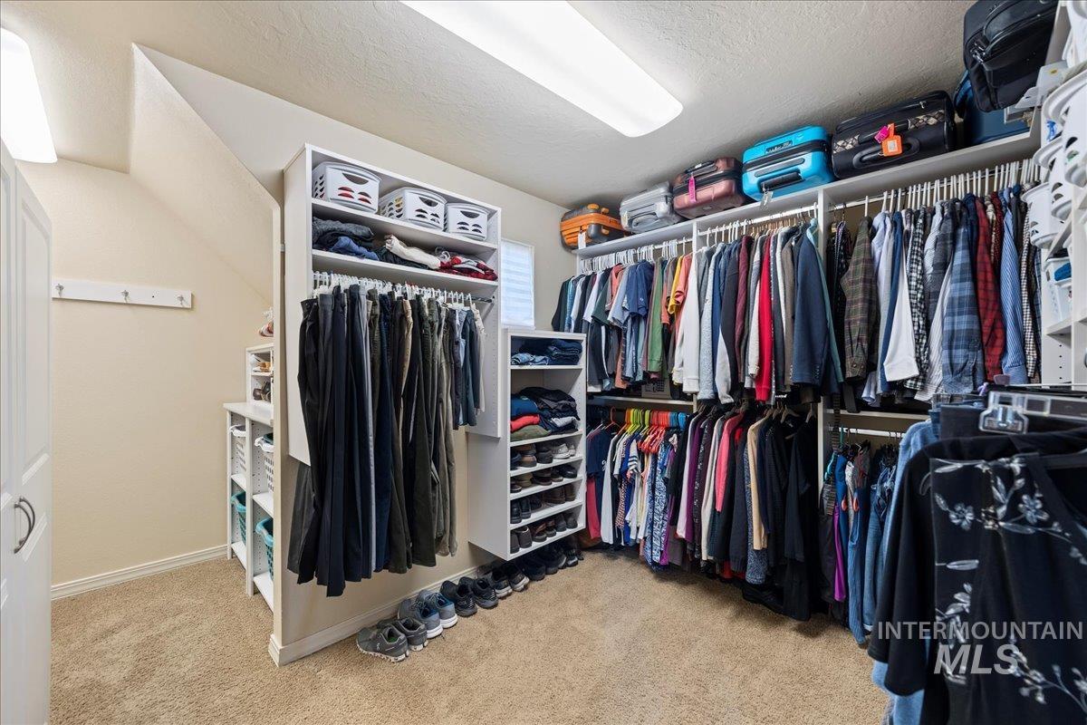 Walk in closet featuring light carpet