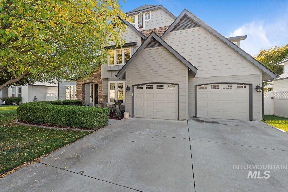 View of front of house featuring concrete driveway and stone siding