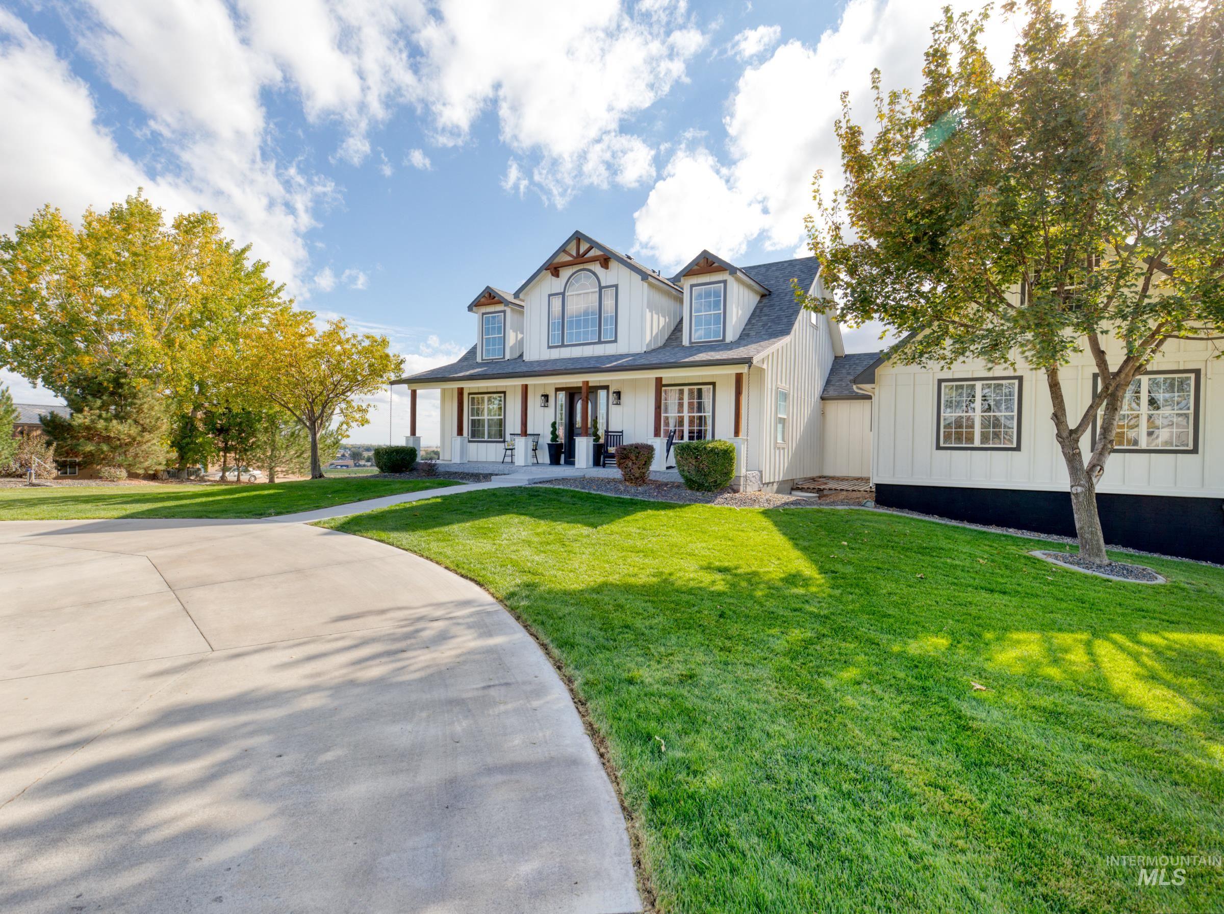 Modern farmhouse style home with board and batten siding, covered porch, and a front yard