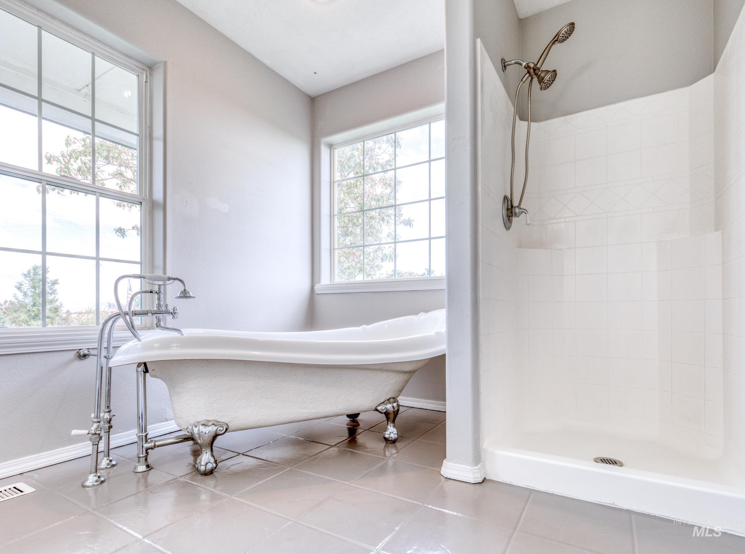Full bathroom with a stall shower, light tile patterned floors, and a freestanding tub