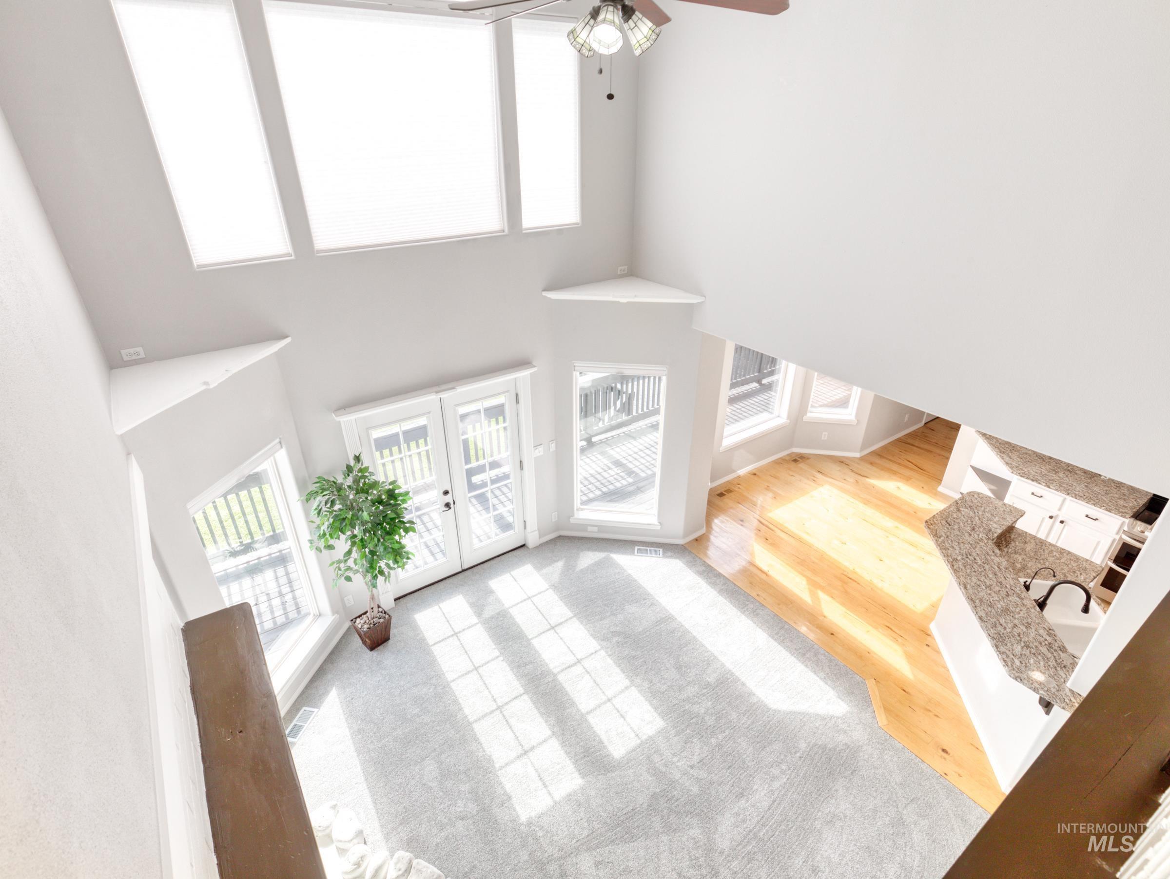 Entrance foyer with a high ceiling, light wood finished floors, french doors, and ceiling fan