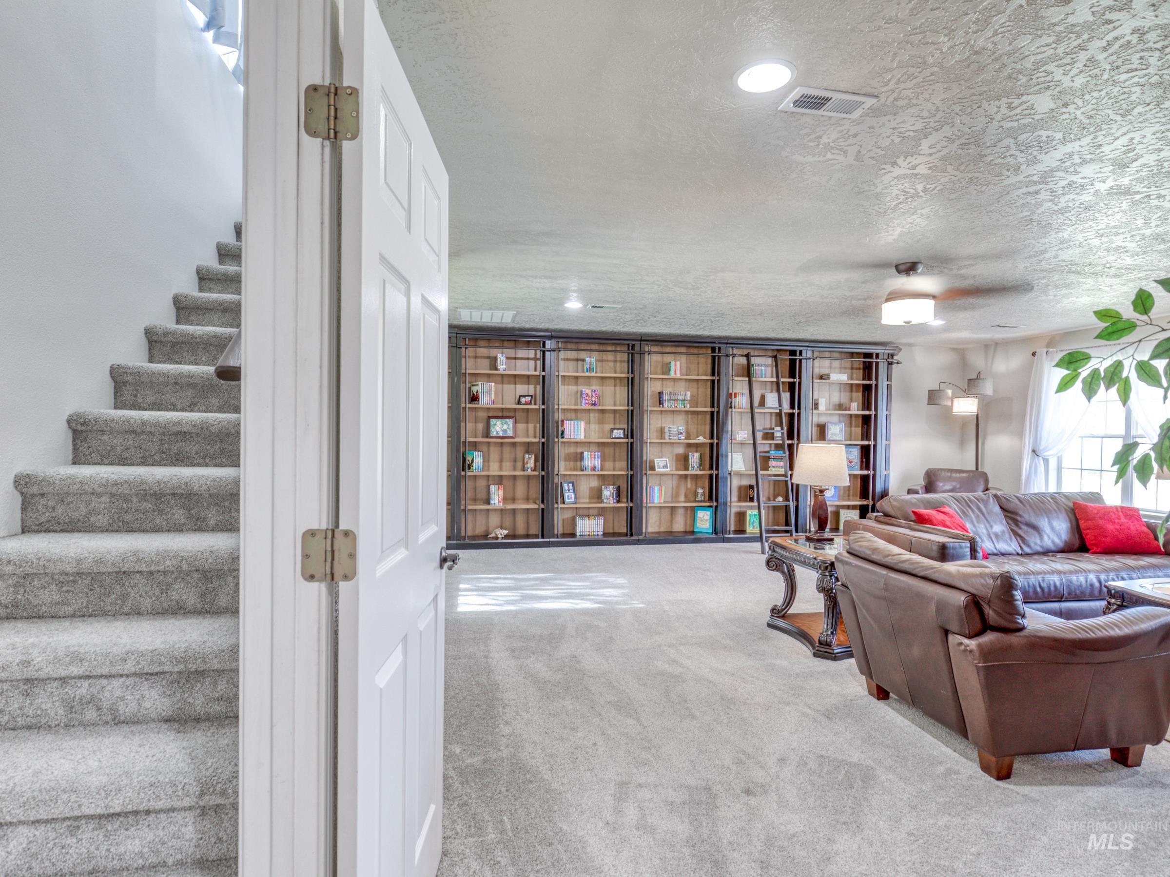 Carpeted living area with stairs and a textured ceiling