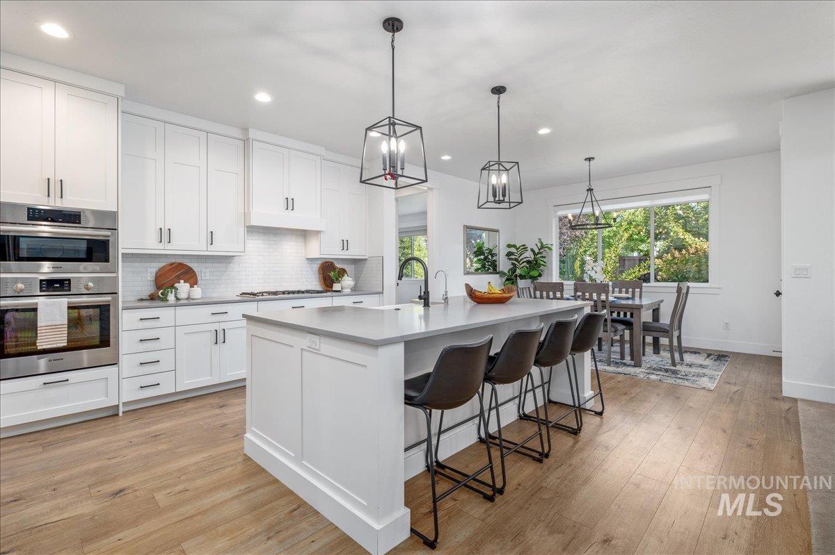 Kitchen with decorative backsplash, healthy amount of natural light, light wood finished floors, and recessed lighting