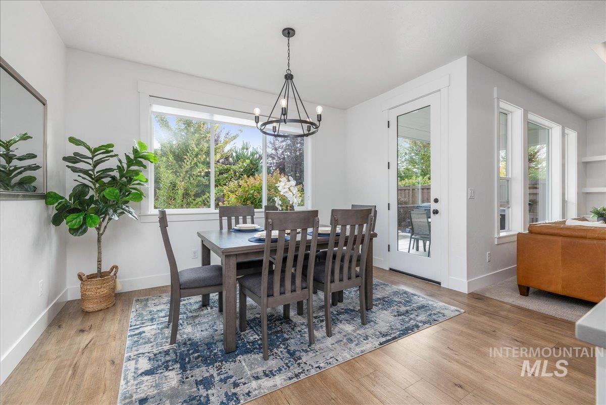 Dining room with plenty of natural light, light wood finished floors, and a chandelier