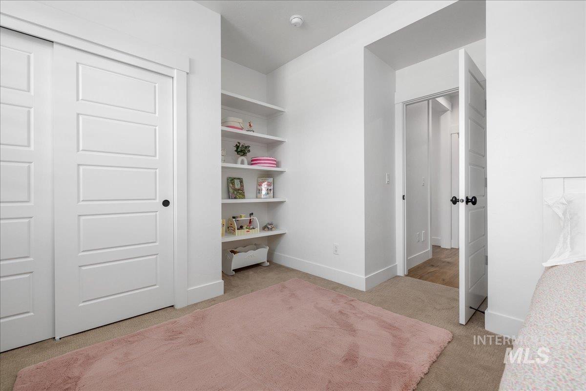 Bedroom with light carpet and a closet