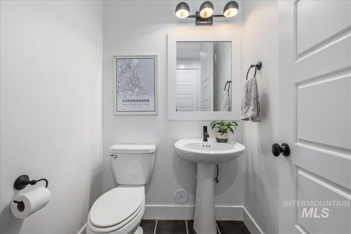 Half bathroom featuring toilet and baseboards