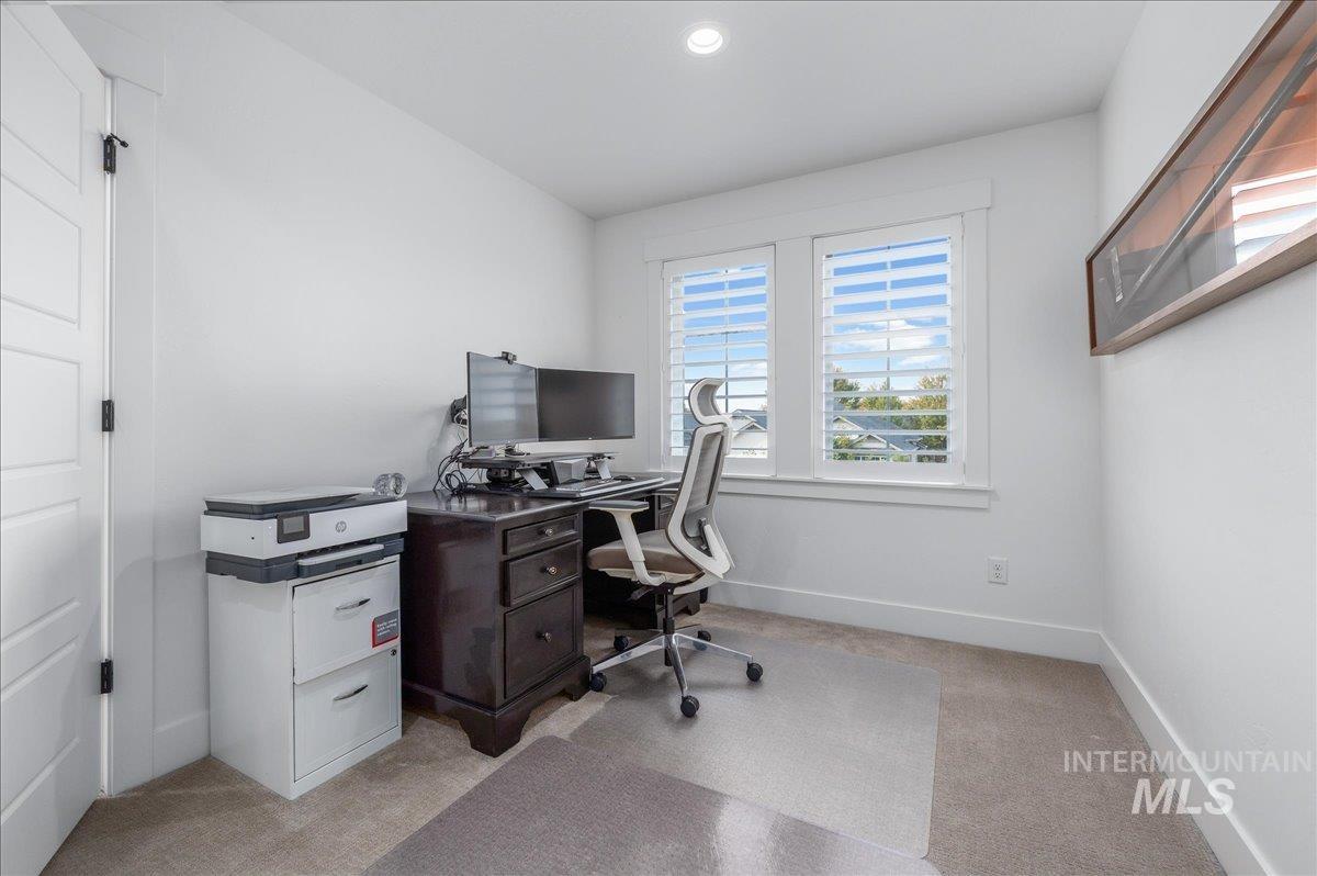 Office with light colored carpet and recessed lighting