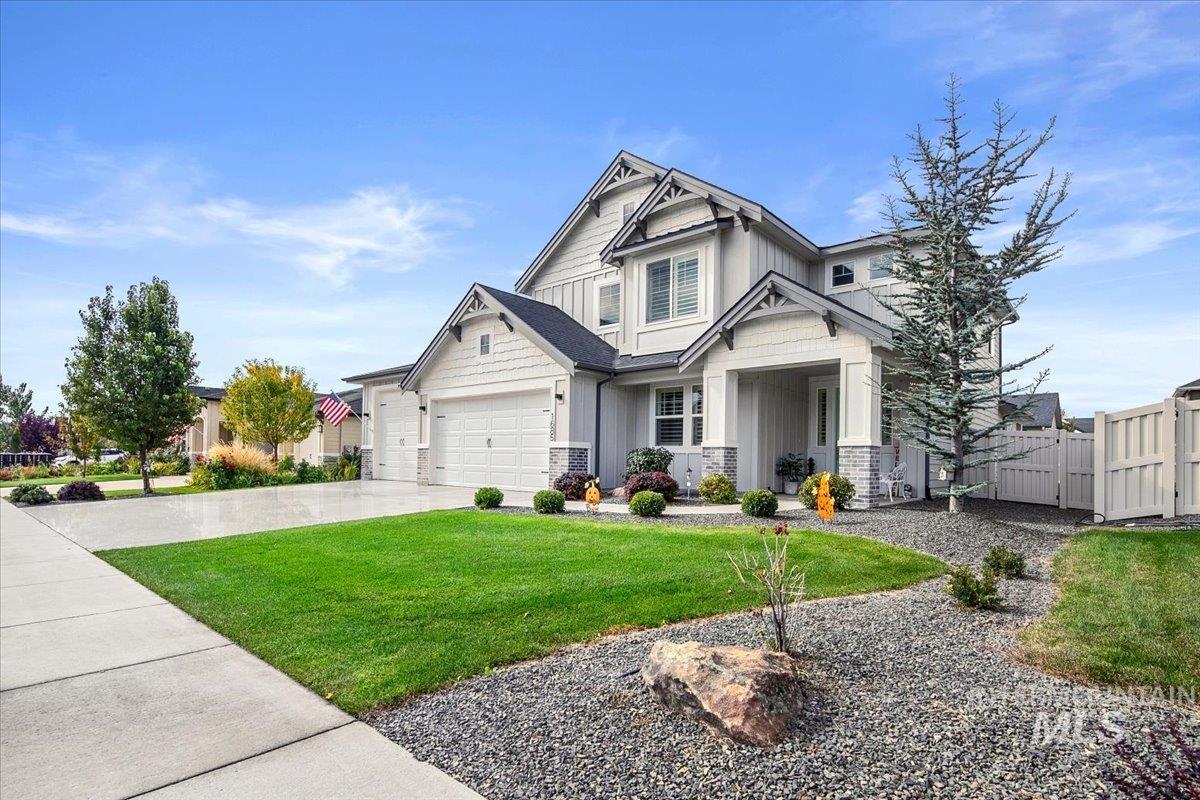 Craftsman-style house with board and batten siding, concrete driveway, and a gate
