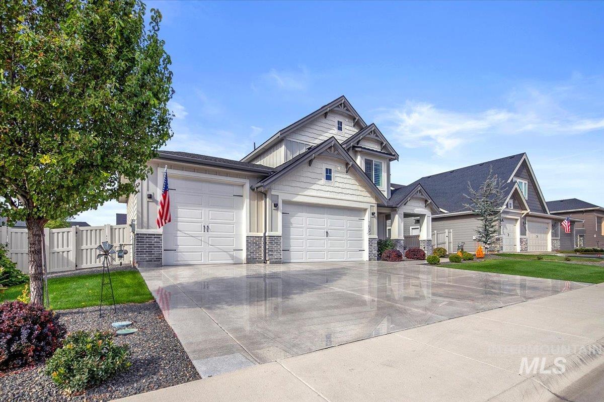 Craftsman house with an attached garage, driveway, and stone siding