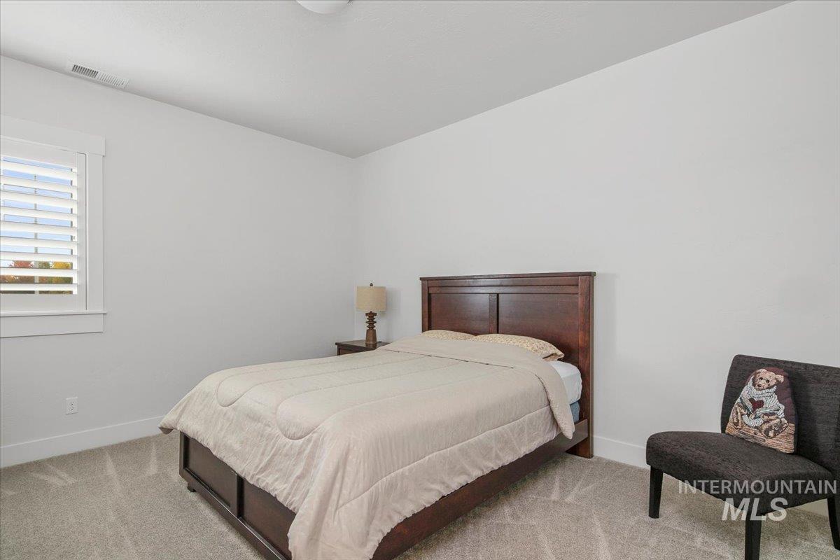 Bedroom featuring light colored carpet and baseboards