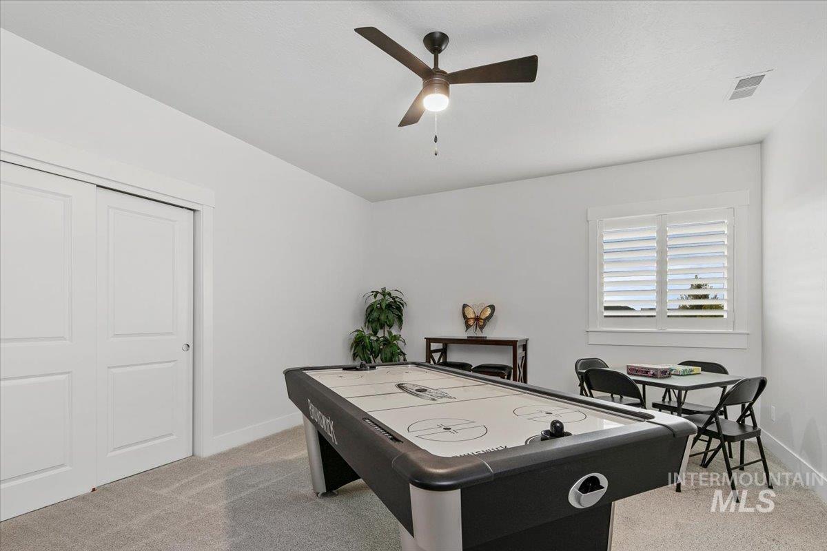 Playroom featuring light colored carpet and ceiling fan