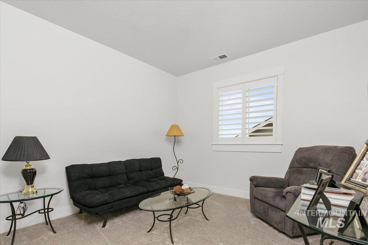 Living area featuring carpet flooring and baseboards
