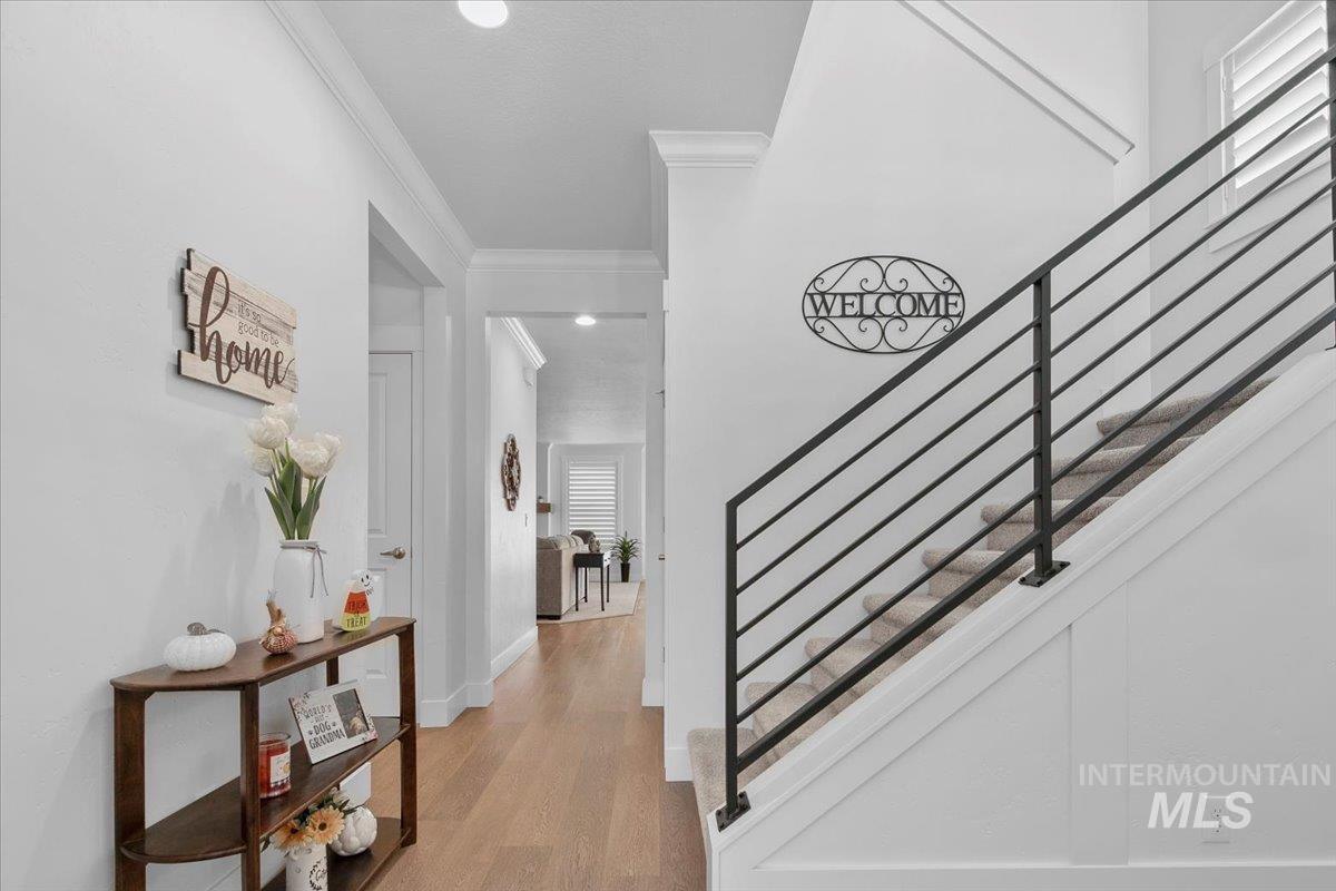 Stairway featuring ornamental molding, wood finished floors, and recessed lighting