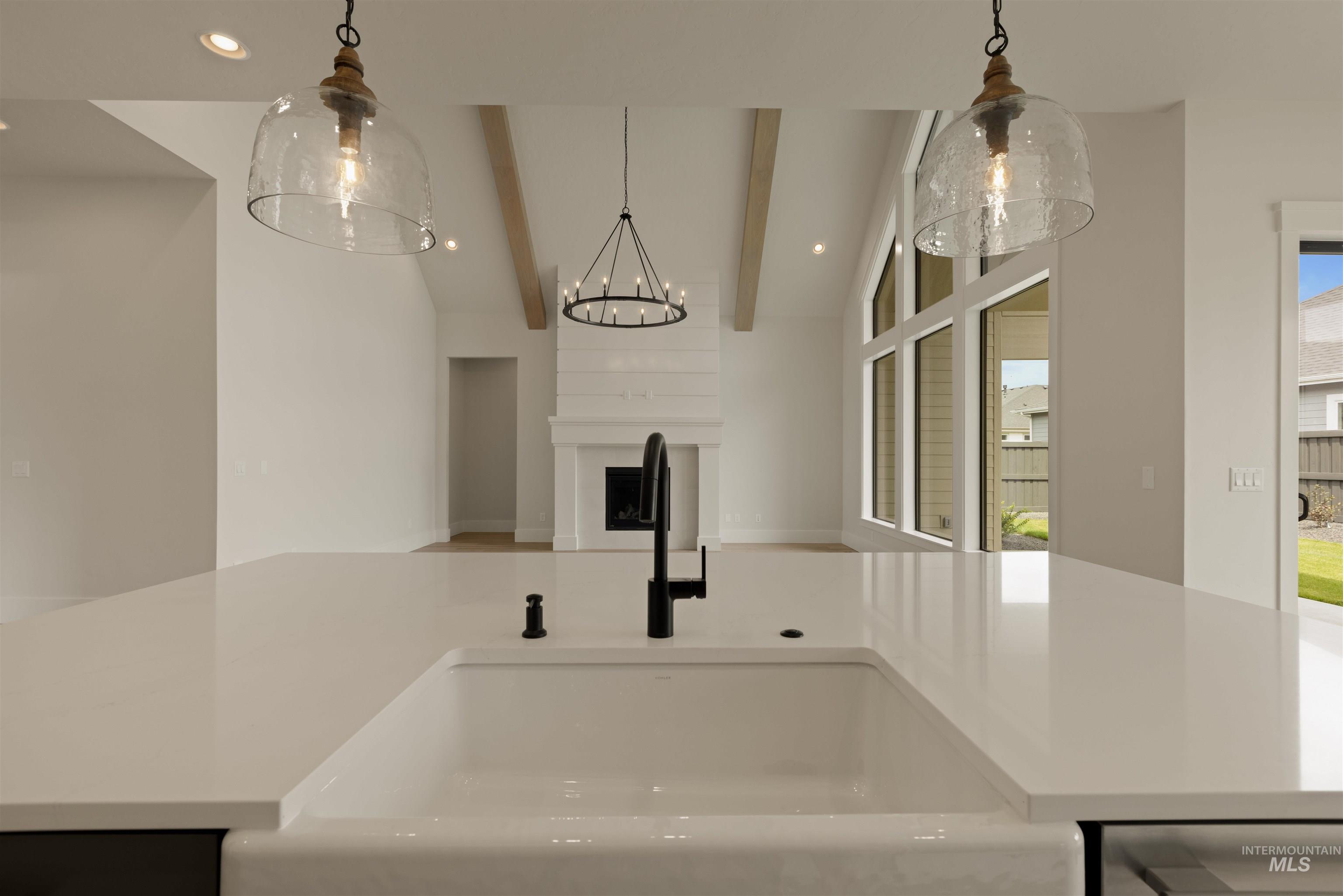 Kitchen with recessed lighting, pendant lighting, open floor plan, and light stone counters