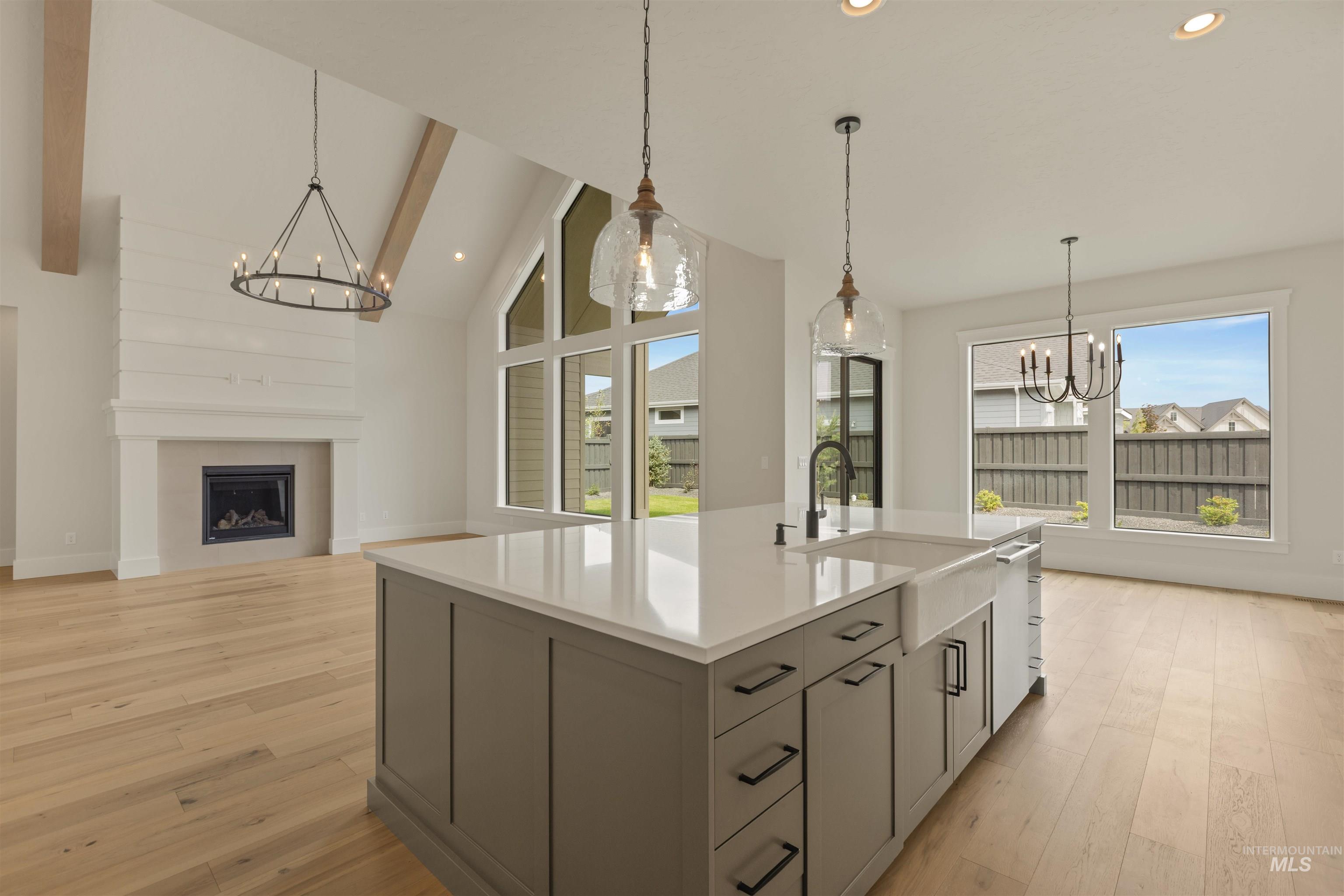 Kitchen with a chandelier, hanging light fixtures, light wood-type flooring, a fireplace, and recessed lighting