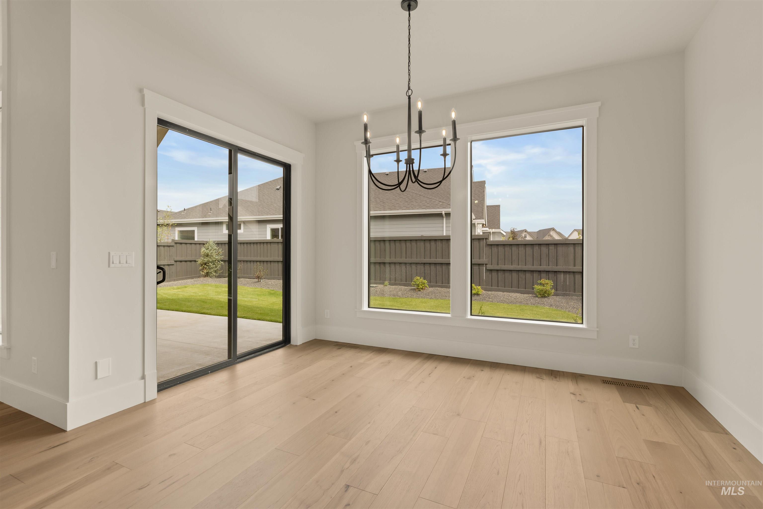 Unfurnished dining area featuring a chandelier and light wood-style floors