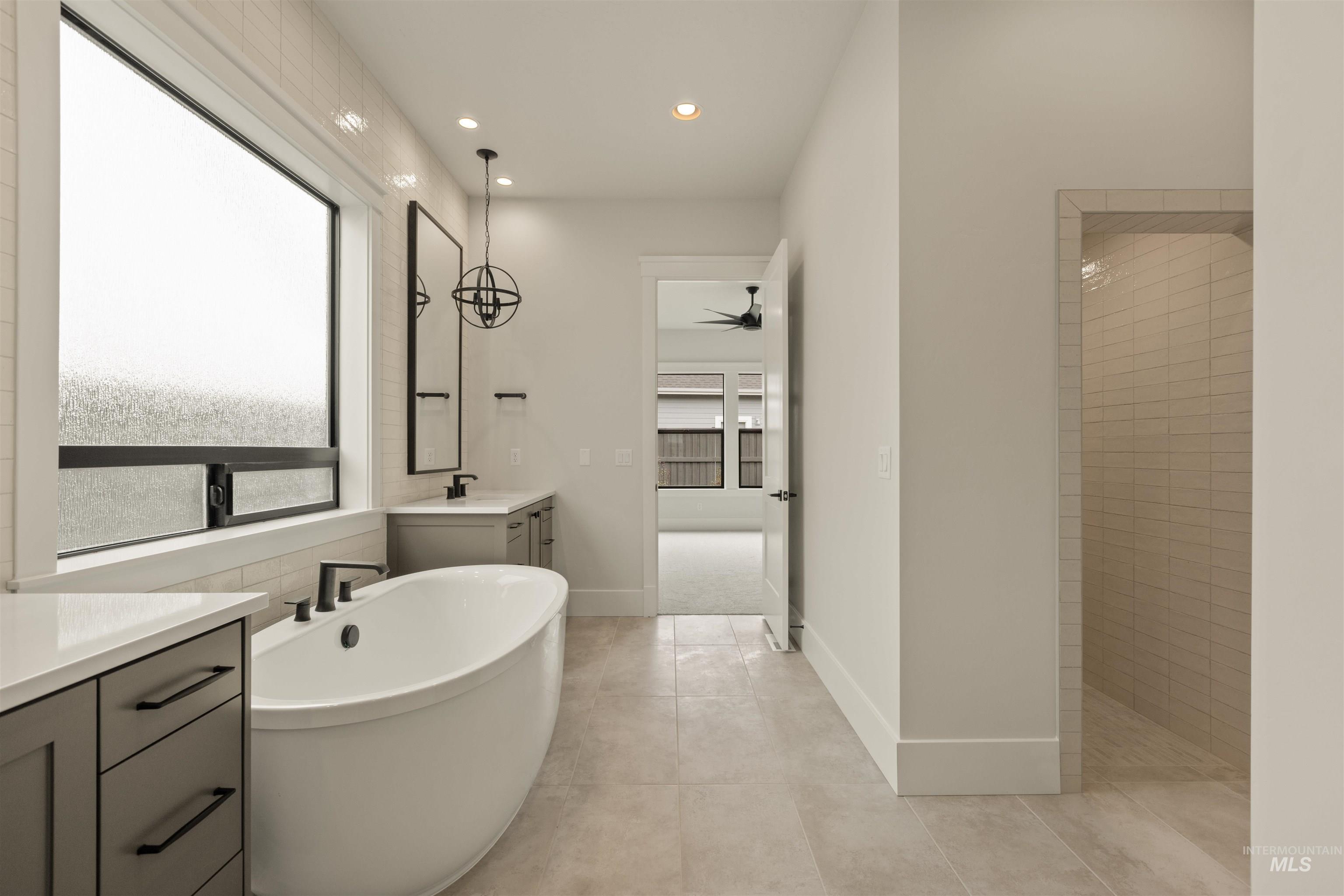 Full bath with vanity, a soaking tub, recessed lighting, ceiling fan, and light tile patterned flooring