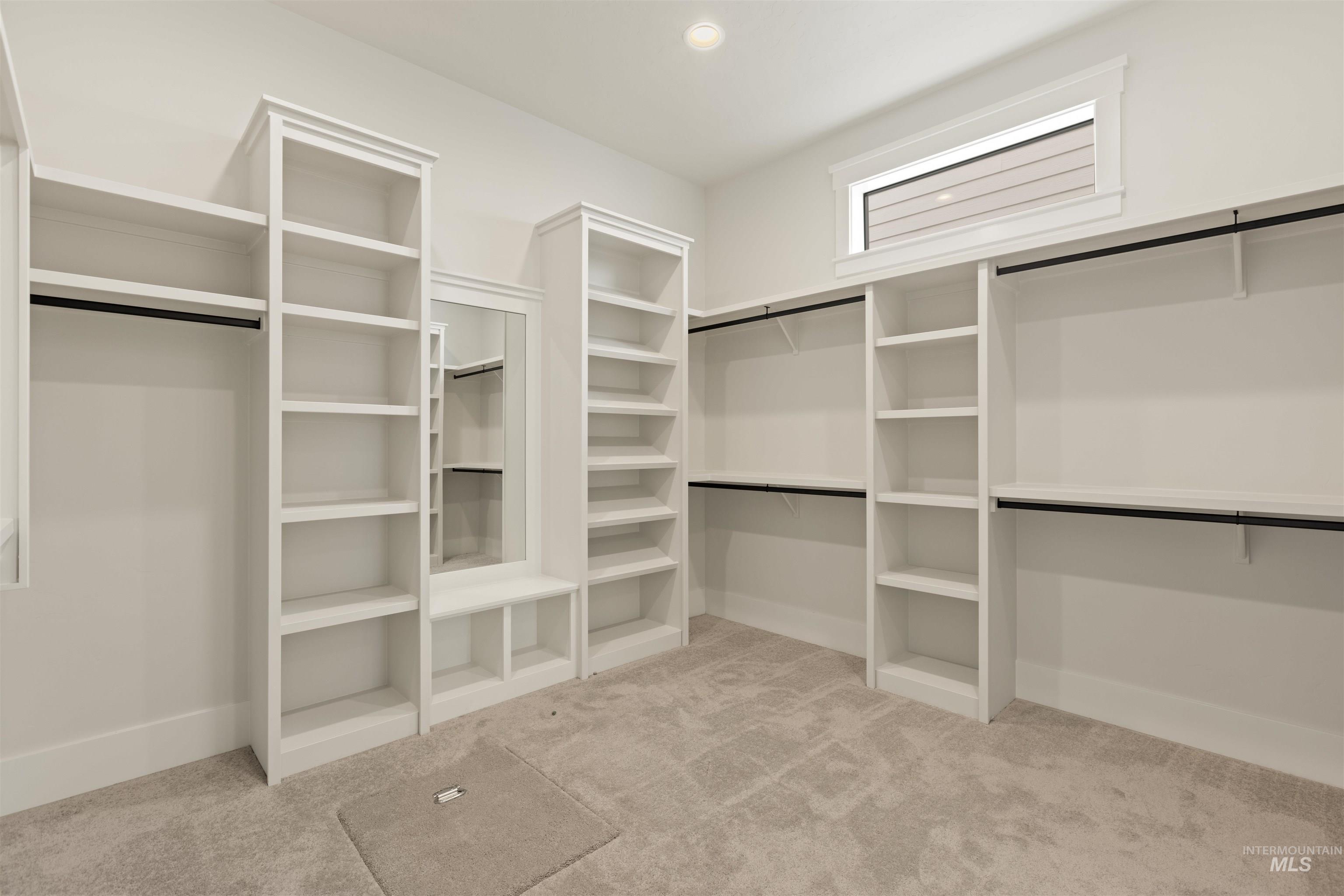 Spacious closet with light colored carpet
