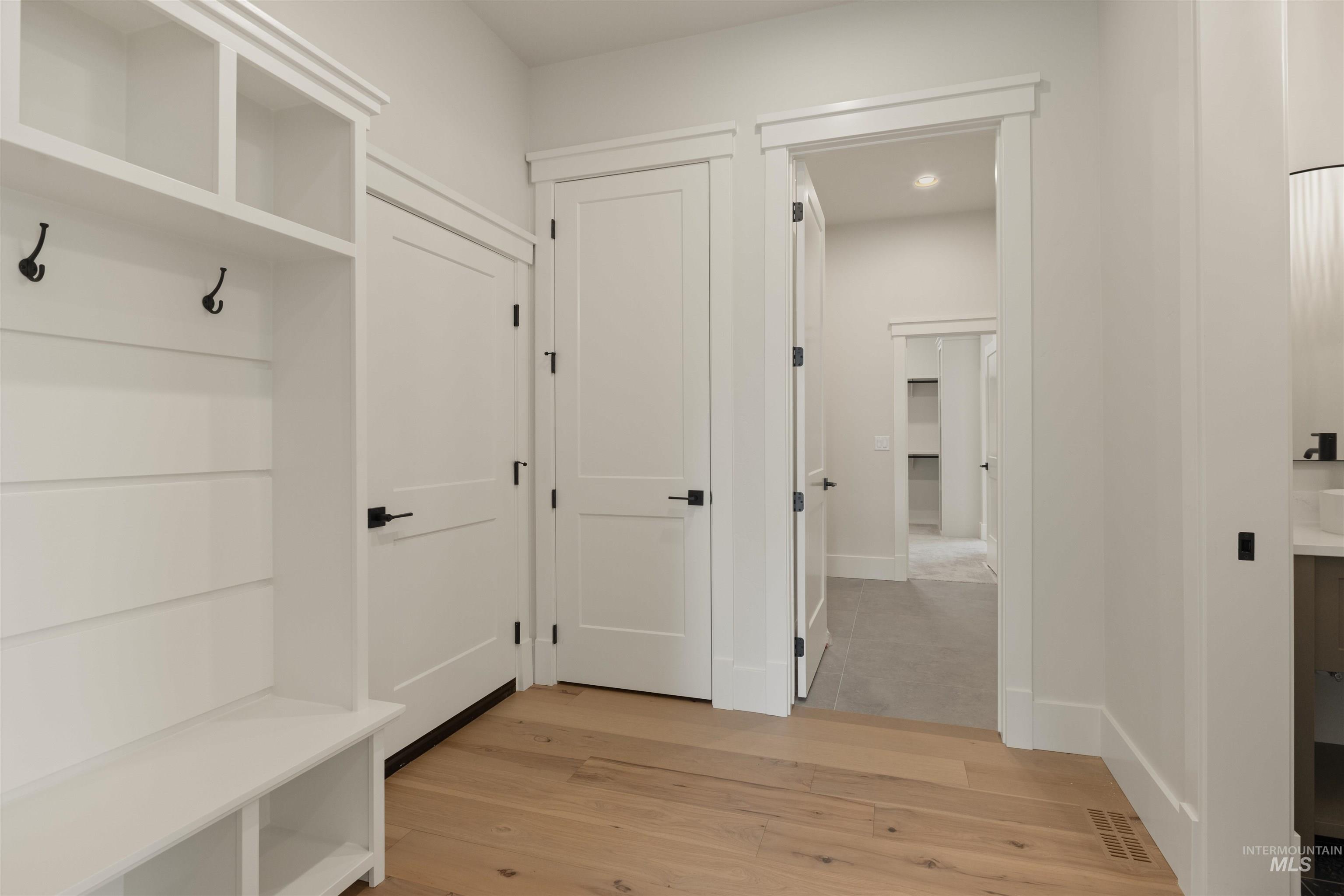 Mudroom featuring light wood finished floors and baseboards