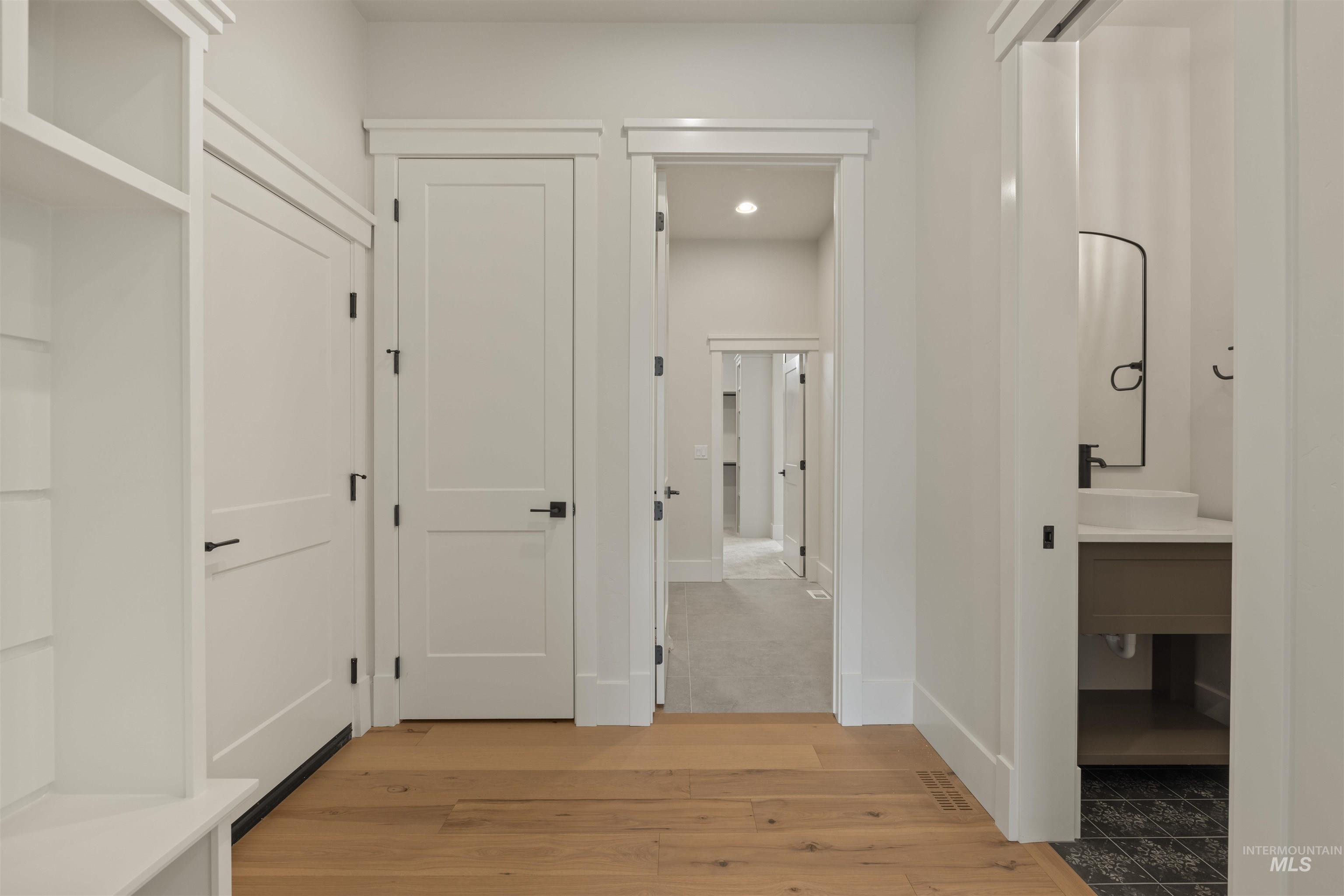 Hall with light wood-style floors and recessed lighting
